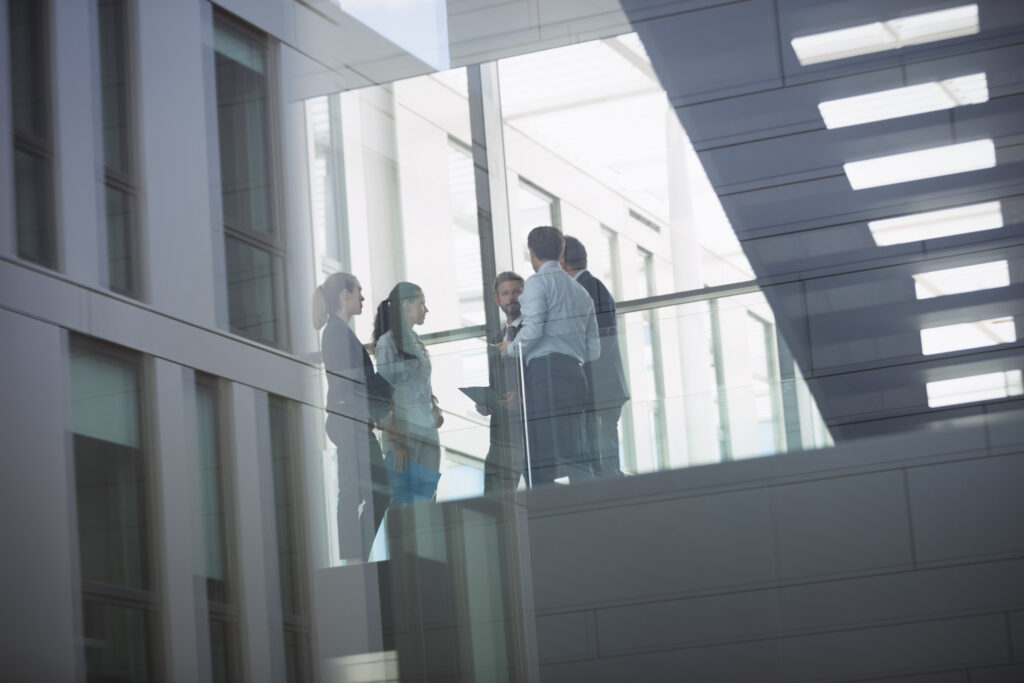 group of businesspeople interacting in corridor of an office building